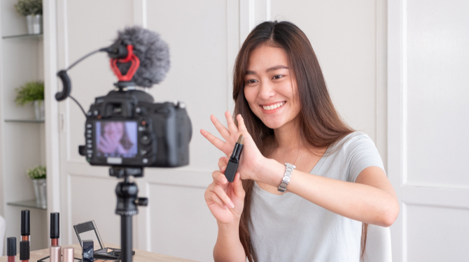 Asian young female blogger recording vlog video with makeup cosmetic at home online influencer on social media concept.live streaming viral