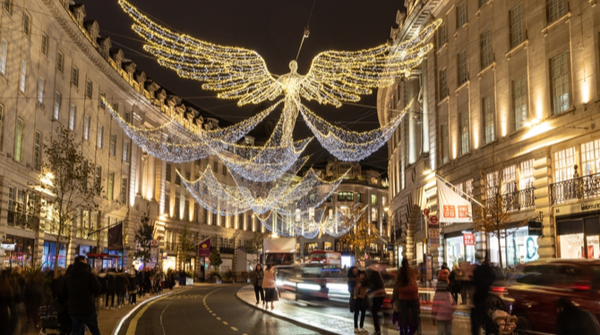 LONDON, UK - 20TH NOV 2021: Views along Regent Street in London at Christmas showing the decorations and outside of shops. People can be seen outside.